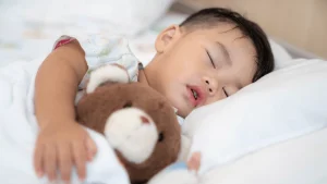Bé đang ngủ sâu giấc trong phòng tối, không gian thoáng mát.